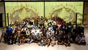 The Family of JaF at the opening of the Village Video Festival.Family of JaF on the occasion of the opening of the Village Video Festival. The photo shows a very large group of about 40 people all smiling and gesticulating, for example, the peace sign, looking at the camera. In the first row are mostly children or young people.