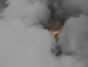 Das Foto zeigt grauen Rauch, in der Mitte etwas leicht orange Helles. Im ersten Moment erinnert es an einen Vulkanausbruch.