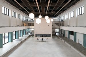 The venue Hallenbad Ost from the inside. A large room reminiscent of an old swimming pool. There is no water in the pool, but one can walk on the inside of the old pool.