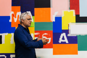 Richard Bell in front of one of his artworks.