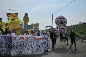 Karneval zum Gedenken an die Schlammtragödie von Lapindo vor 4 Jahren in Siring Barat. Menschen ziehen mit Kostümen und Pannern über die Straße.