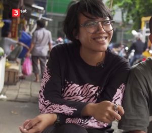 Screenshot of the documentary shows a smiling woman