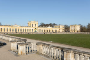 Auf dem Foto ist die große Karlswiese und die gelb leuchtende barocke Fassade des Orangerie-Schlosses zu sehen.