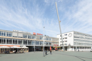 Das Foto zeigt den Eingangsbereich des Kulturbahnhofs, davor den großzügigen Vorplatz, auf dem die Skulptur 