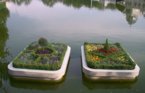 Foto: zwei Blumenbeete die in einer schwimmenden Box auf dem Fluss platziert sind.
