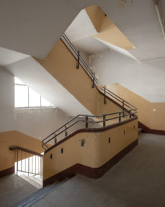 Das Foto zeigt ein Treppenhaus mit abblätterndem Putz an den Wänden.